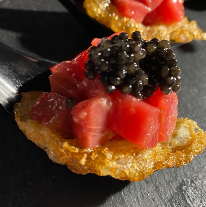 Bocado con caviar sobre base cremosa.